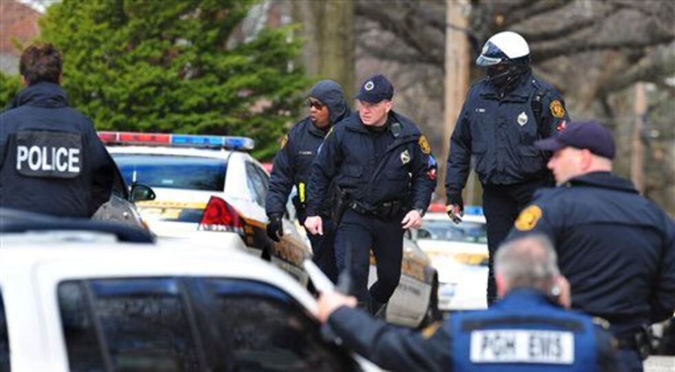Police walk up Fairfield Street in the Stanton Heights area of Pittsburgh where a gunman shot...
