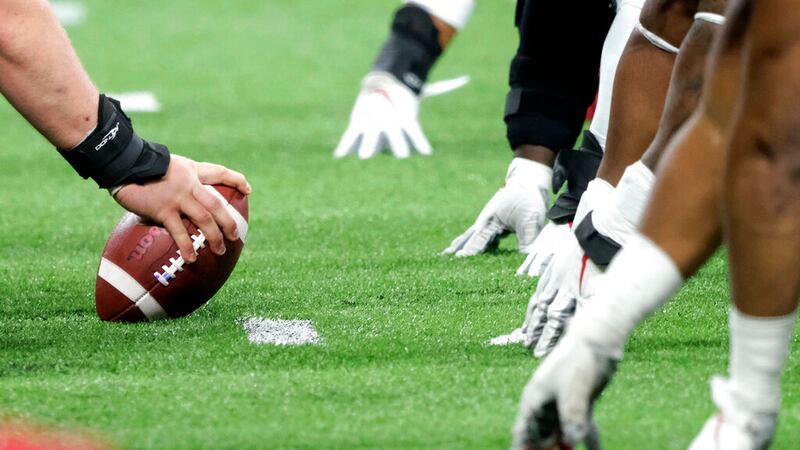 FILE - In this Dec. 7, 2019, file photo, a player prepares to hike the ball at the line of...