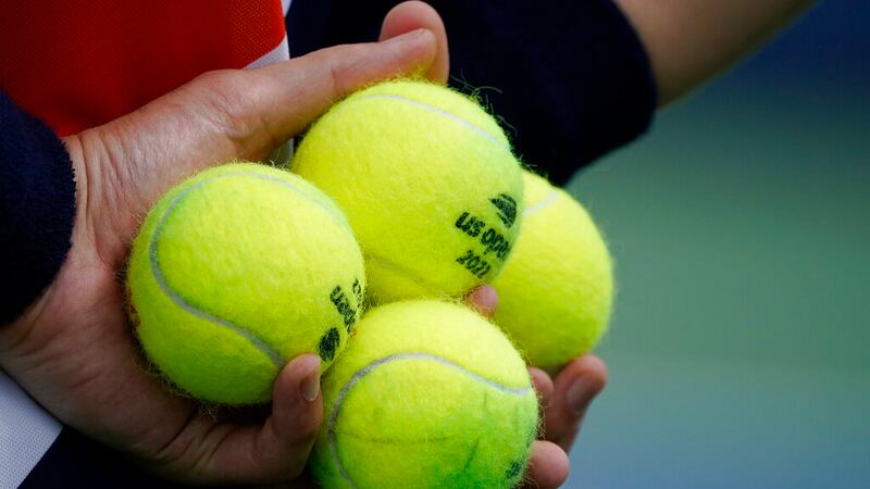 A court attendant holds balls for service during the first round of the US Open tennis...