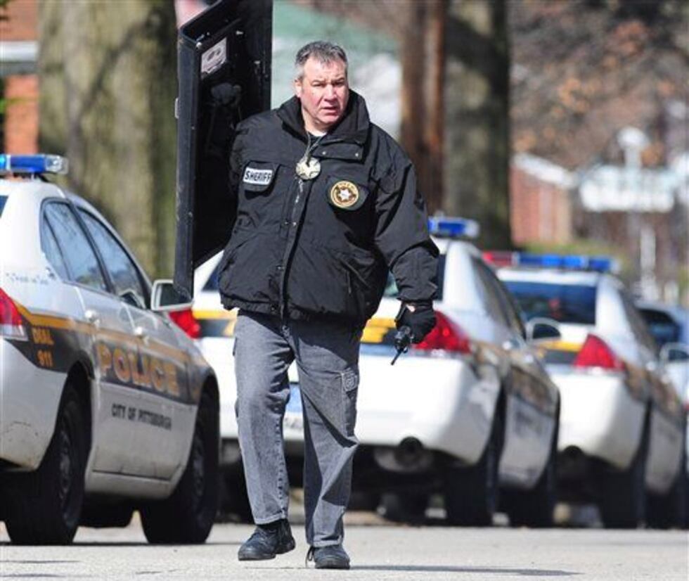 A policeman carries a shield near the seen of a shooting in the Stanton Heights section of...